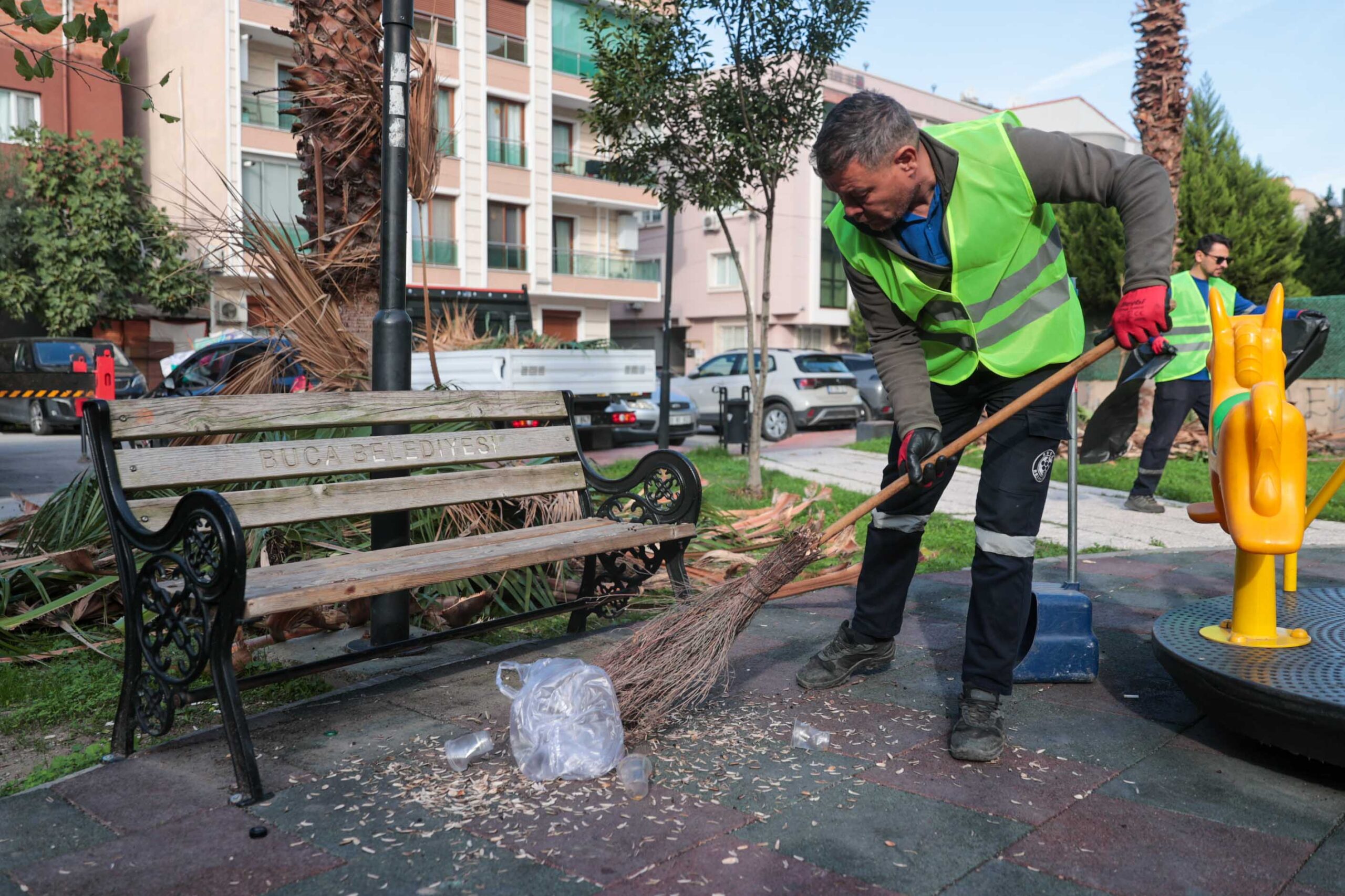 Buca Belediyesi temizlik ekipleri, bir parkta kosa ve budama çalışması yaparken